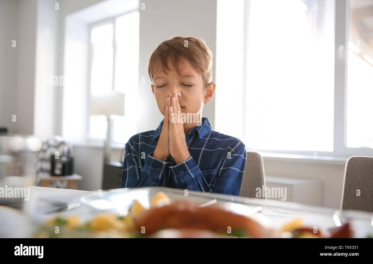 Little boy praying before meal at home Stock Photo