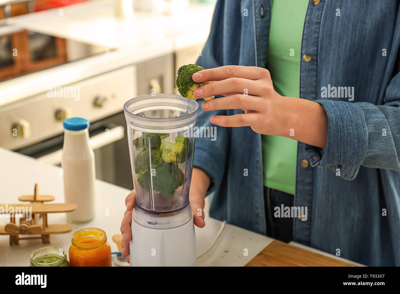 Woman preparing healthy baby food in kitchen Stock Photo