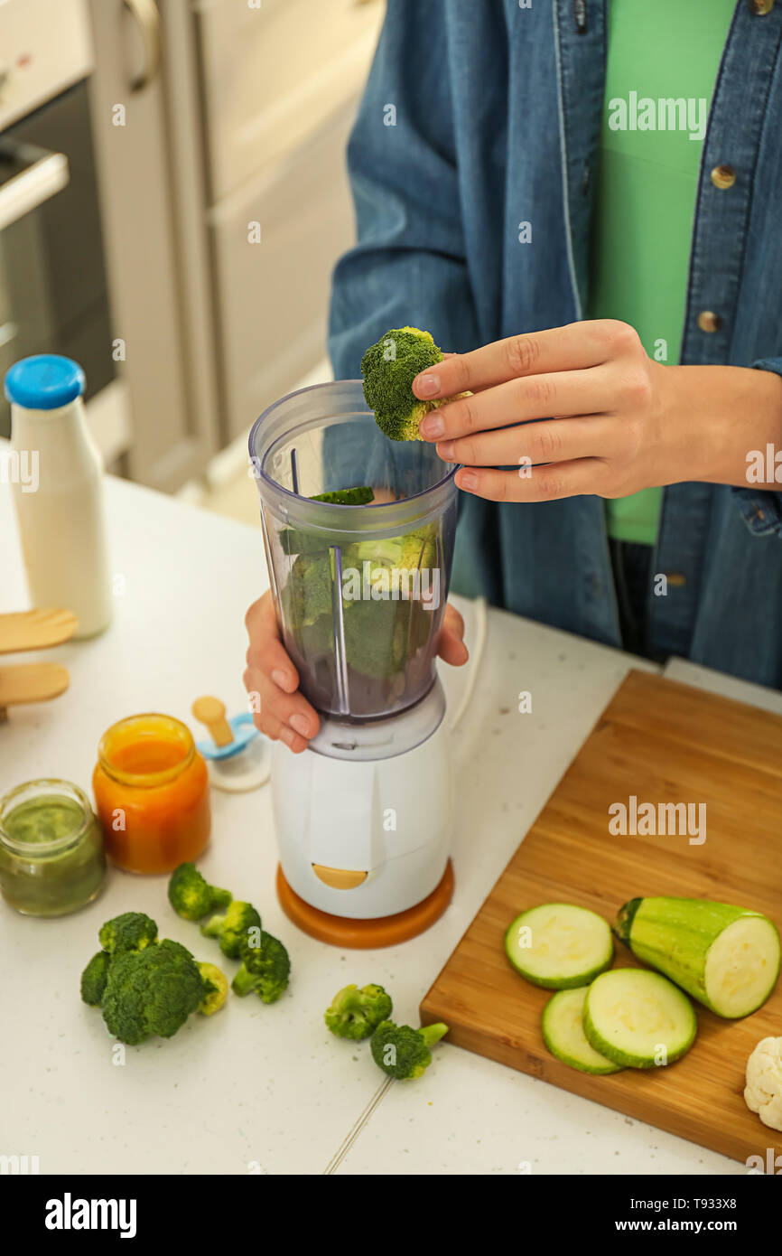 Woman preparing healthy baby food in kitchen Stock Photo