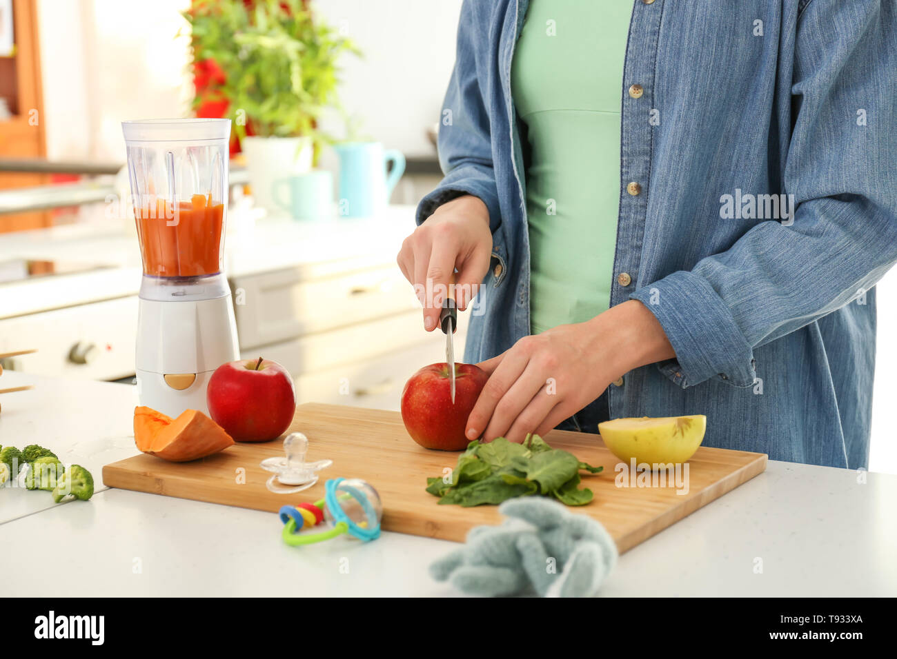 Woman preparing healthy baby food in kitchen Stock Photo