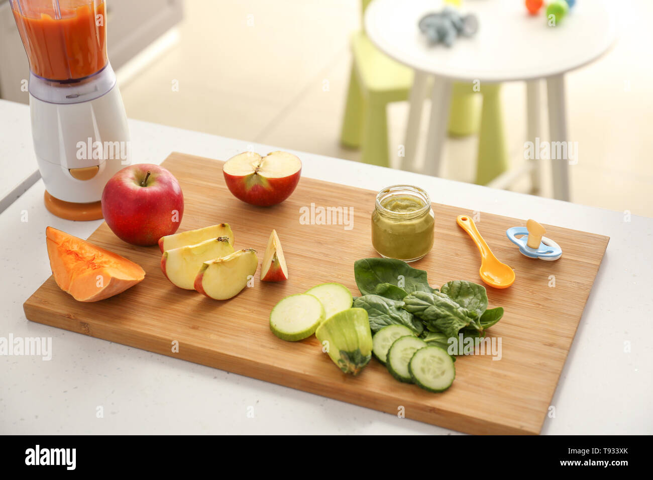 Wooden board with ingredients for baby food on kitchen table Stock Photo