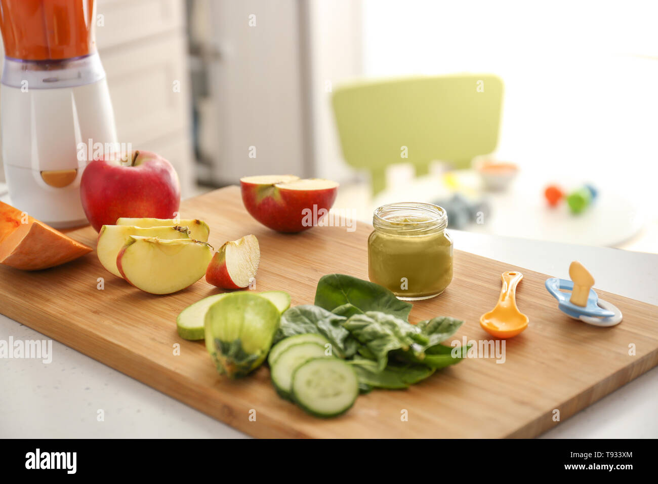 Wooden board with ingredients for baby food on kitchen table Stock Photo