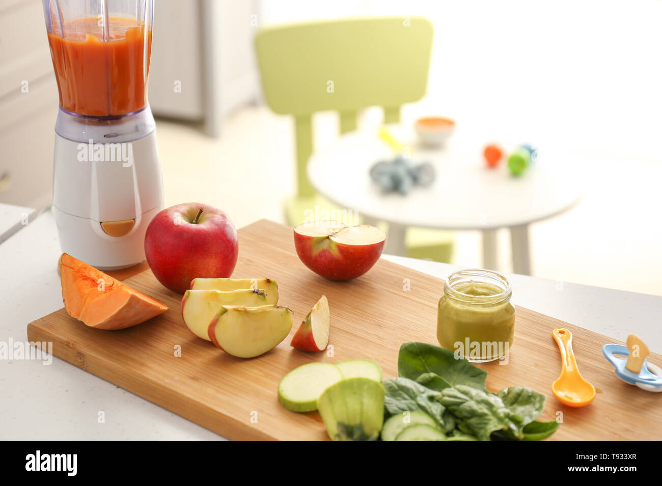Wooden board with ingredients for baby food on kitchen table Stock Photo
