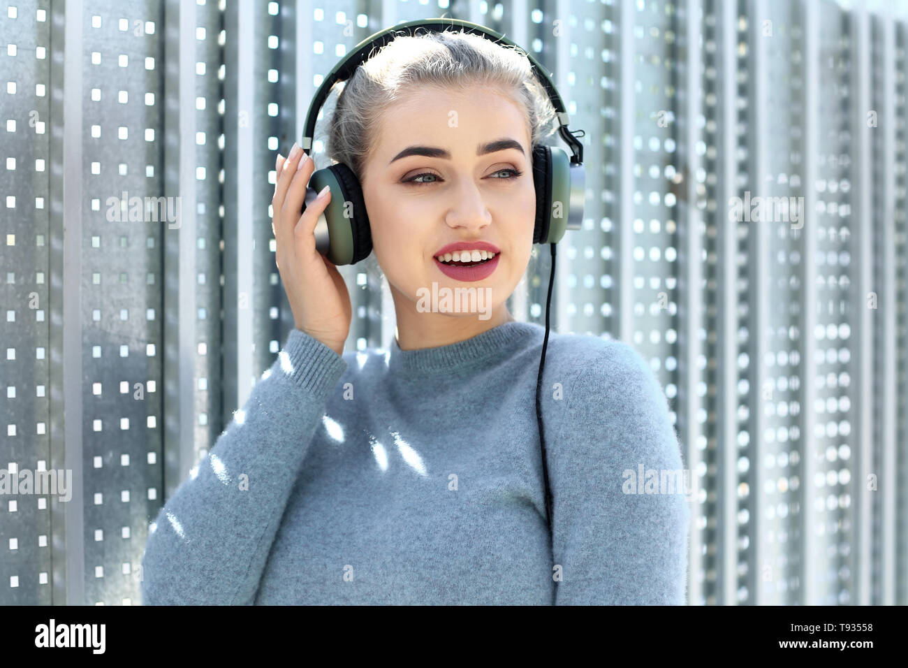 Beautiful young woman listening to music outdoors Stock Photo - Alamy