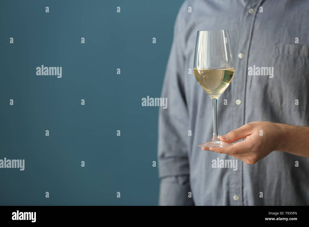 Man with glass of wine on color background, closeup Stock Photo - Alamy