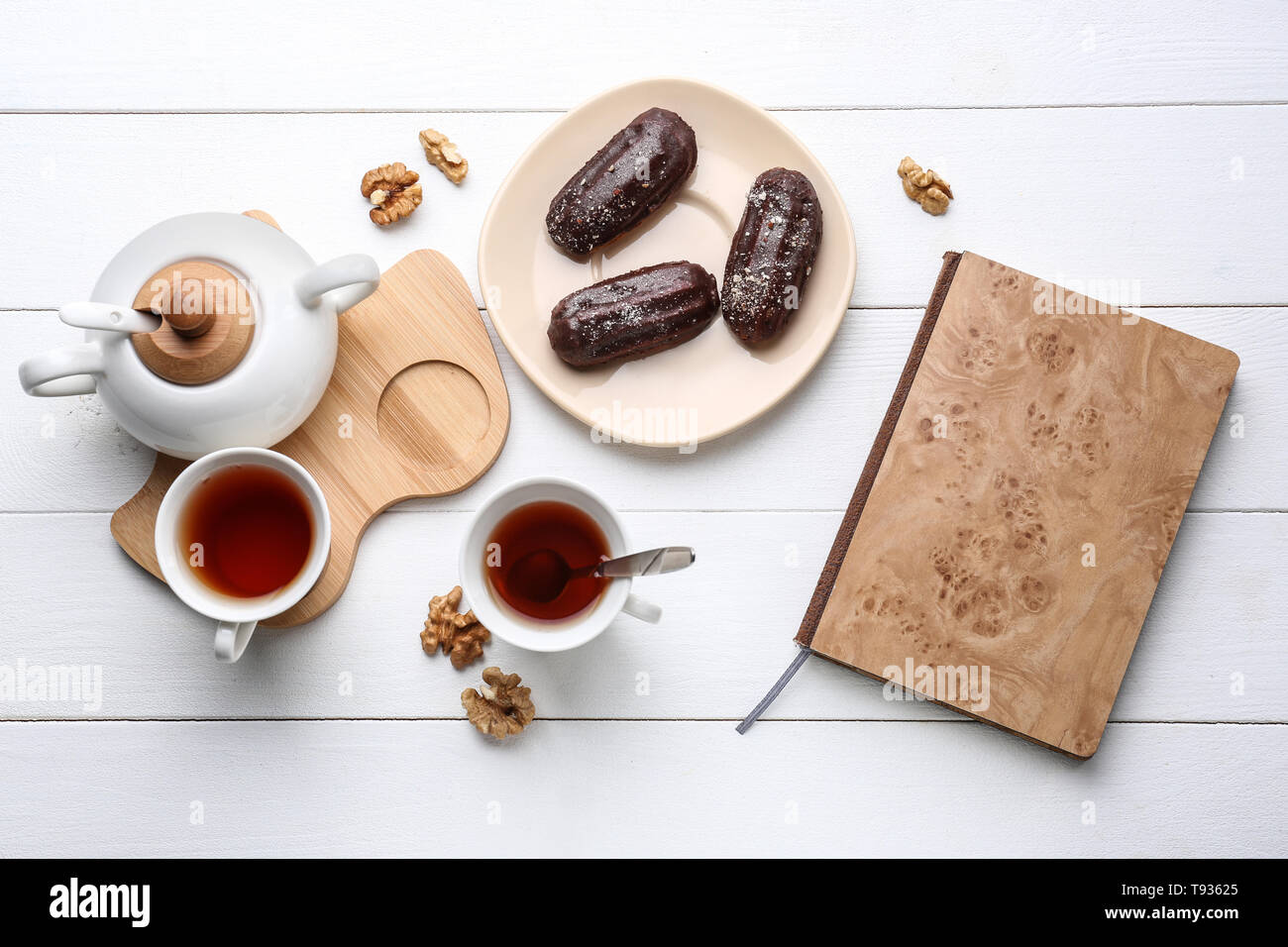 Flat lay composition with delicious eclairs and tea on table Stock Photo