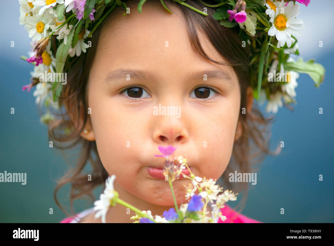 cute girl with flower crown smiling and having fun on meadow Stock Photo