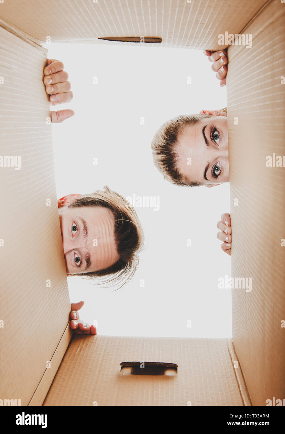 New delivery. Young couple looking into the box while unboxing. Stock Photo