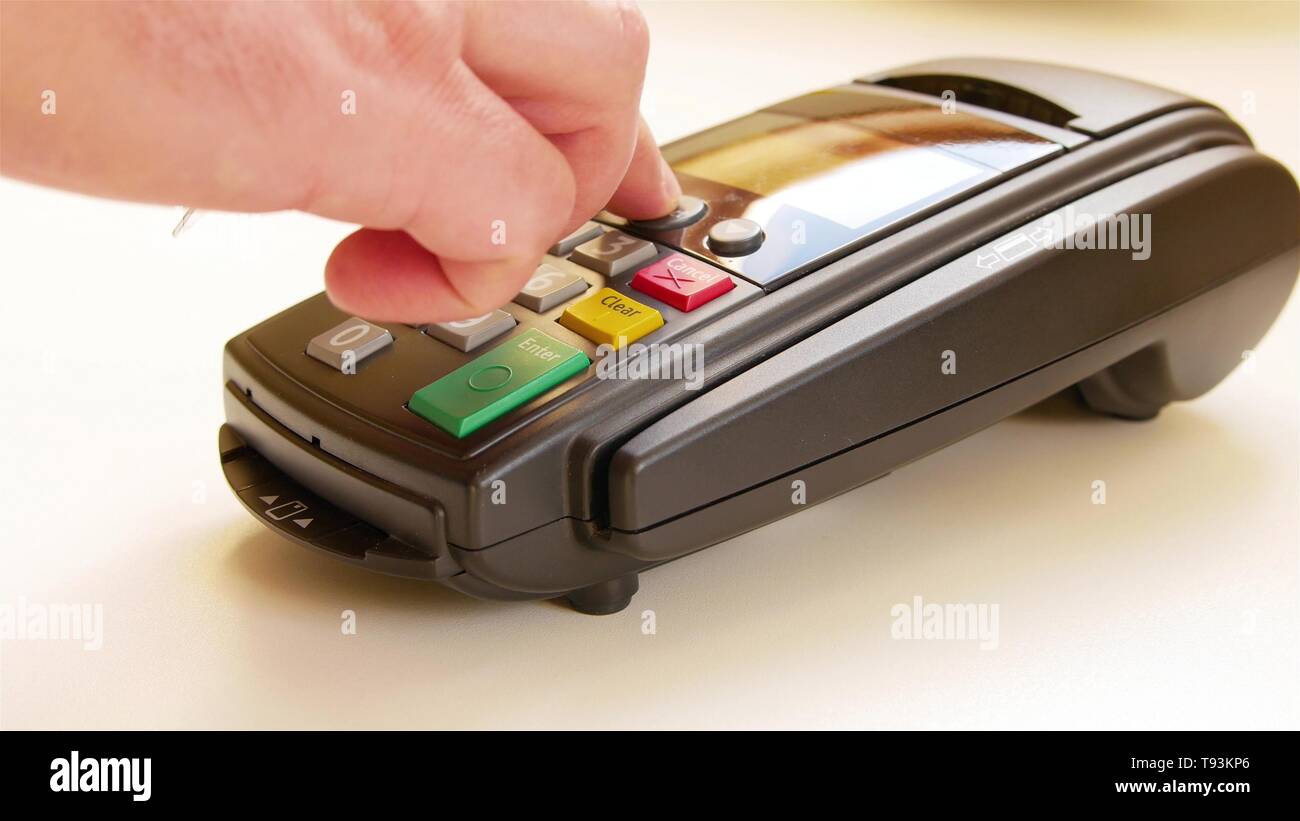 Payment terminal - a finger entering the PIN code Stock Photo - Alamy