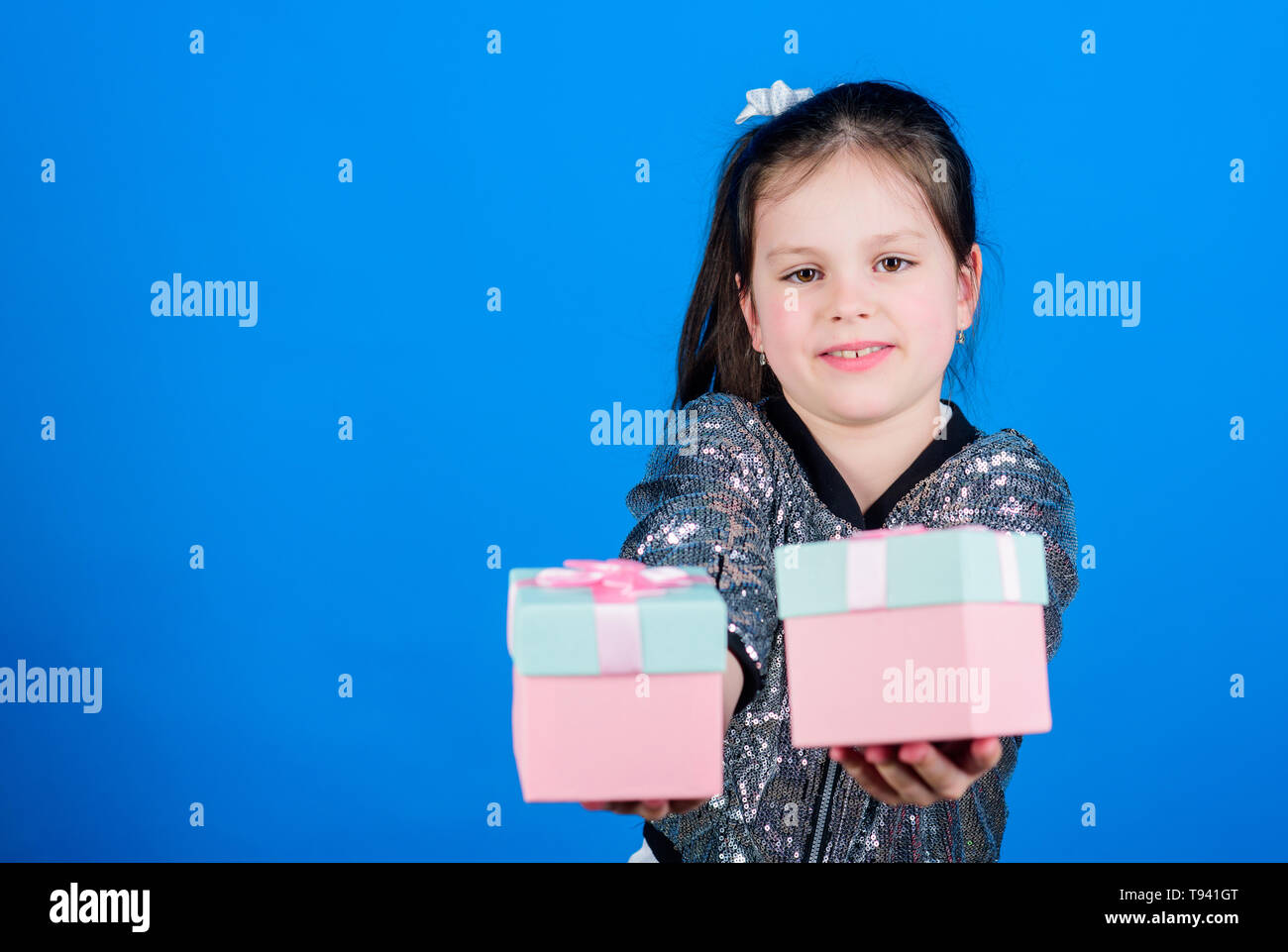 Girl with gift boxes blue background. Black friday. Shopping day. Cute child carry gift boxes. Surprise gift box. Birthday wish list. World of happiness. Special happens every day. Choose one. Stock Photo
