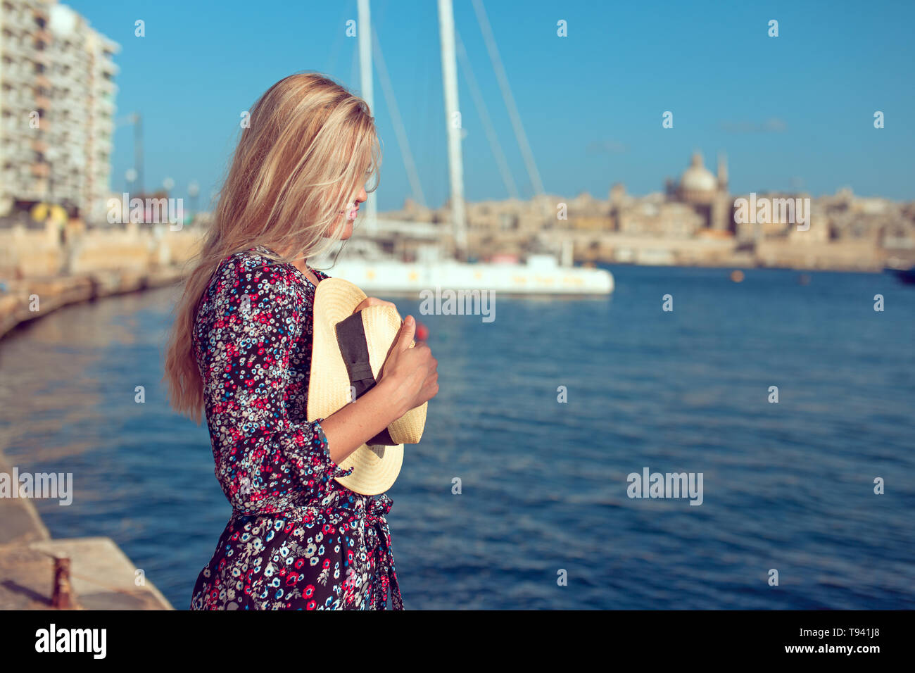 Happy young blonde emotional woman standing at Mediterranean sea Stock Photo