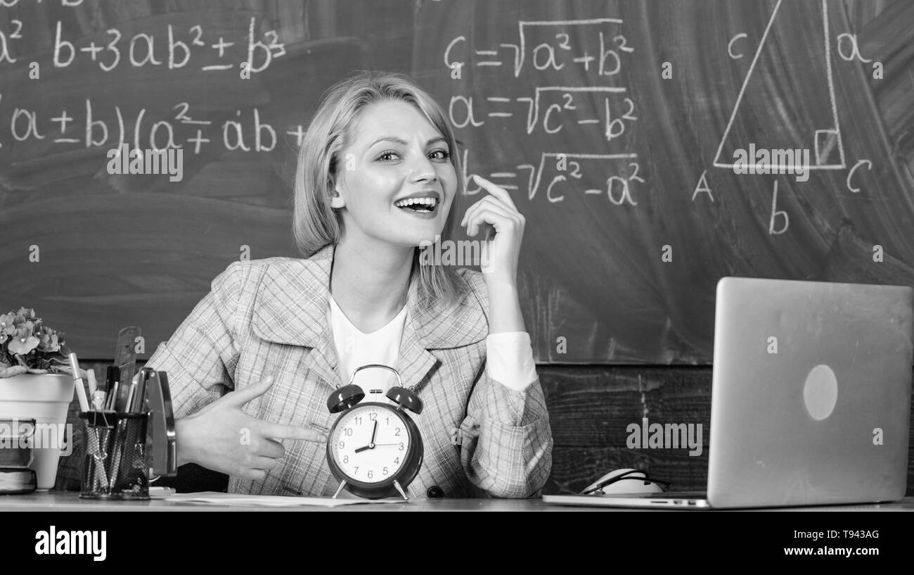 just in time. teacher with alarm clock at blackboard. Time. woman in