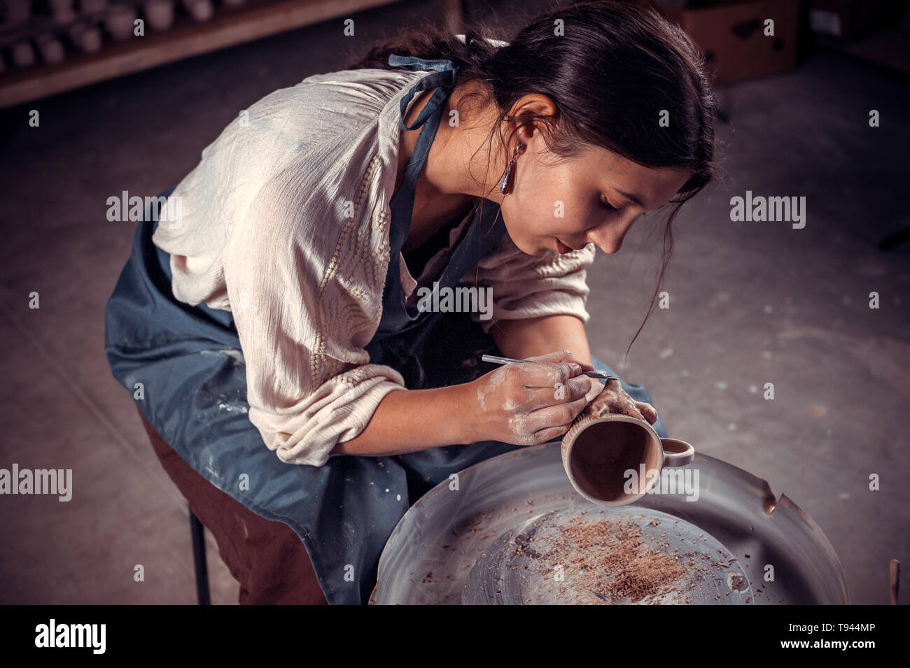 Stylish artisan master working with pottery at the ceramic workshop ...
