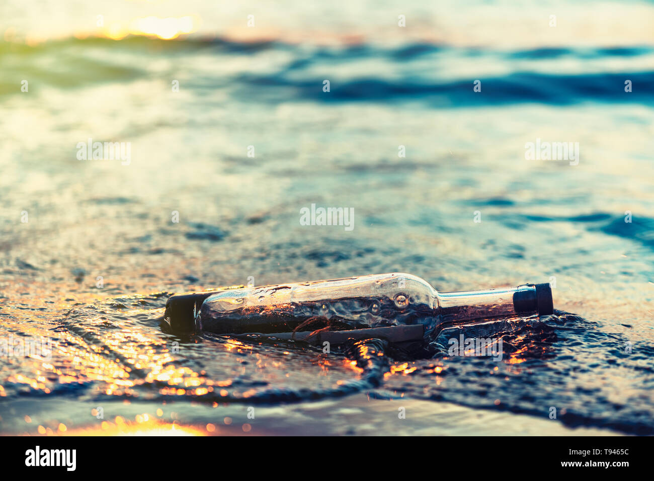 Message in a corked bottle on beach, asking for help Stock Photo