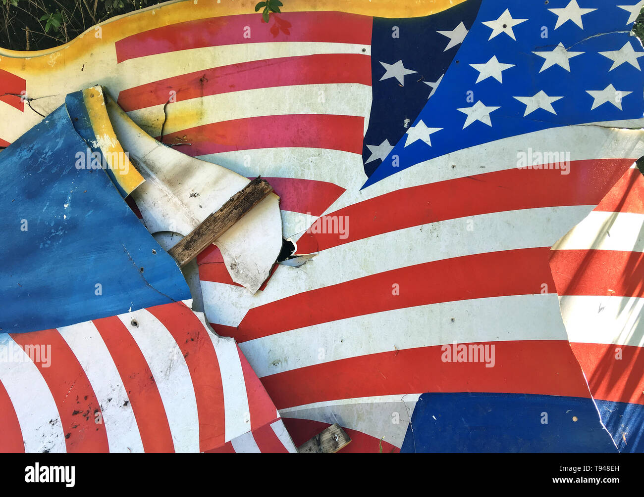 Broken flag, demolished background cardboard with American flag "Stars and Stripes" as motive, disposed at the roadside. Stock Photo