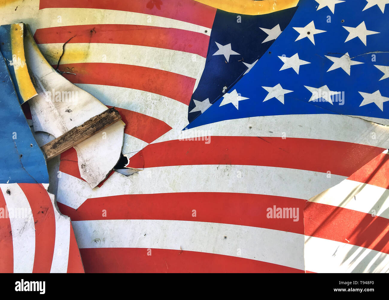 Broken flag, demolished background cardboard with American flag "Stars and Stripes" as motive, disposed at the roadside. Stock Photo