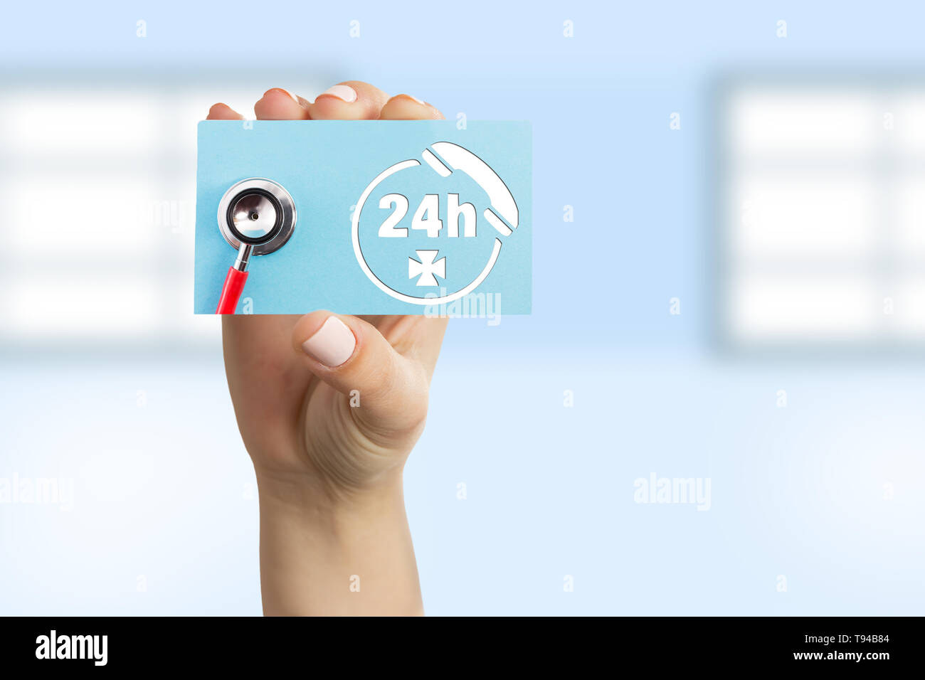 Female doctor showing blue paper card with stethoscope and telephone symbol as contact and non-stop call center concept Stock Photo