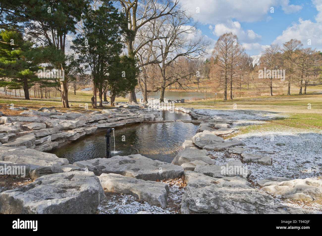 A little snow from the previous night lingers beside the Seven Pools Waterfall at Forest Park on a cold and blustery spring morning. Stock Photo