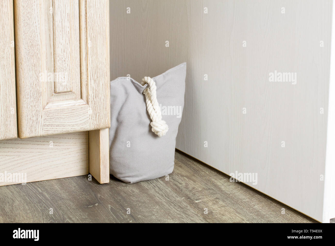 Vintage door stopper made of gray cloth with filling and handle rope Stock Photo