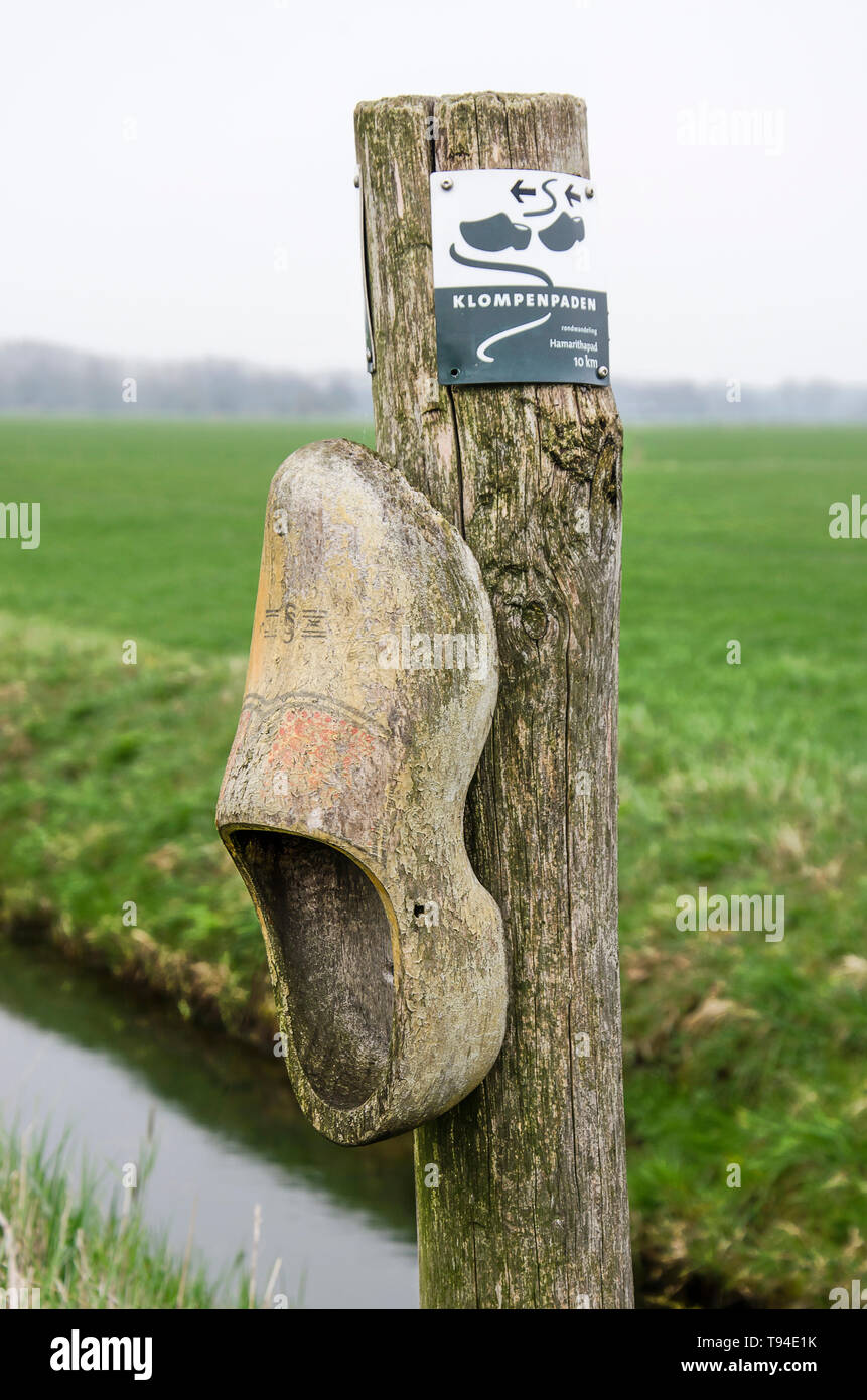 Direction marker on a Klompenpad (Clog Trail) mounted on a pole with a wooden shoe, in a polder landscape near Nederhemert, The Netherlands Stock Photo