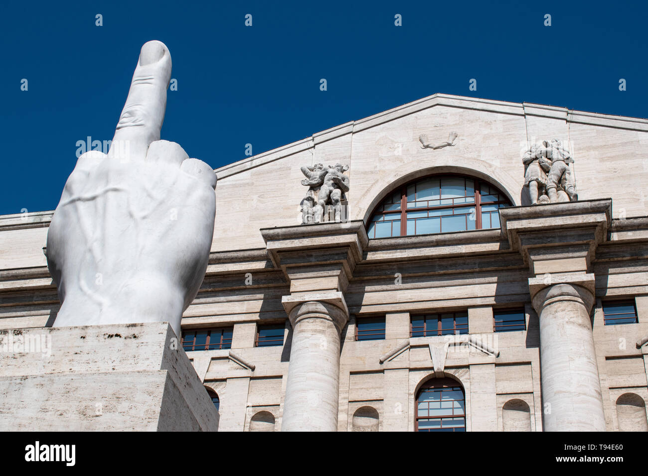 Milan, Italy: L.O.V.E. or The Finger, sculpture made by Maurizio Cattelan in front of Palazzo Mezzanotte, building housing is the Milan Stock Exchange Stock Photo