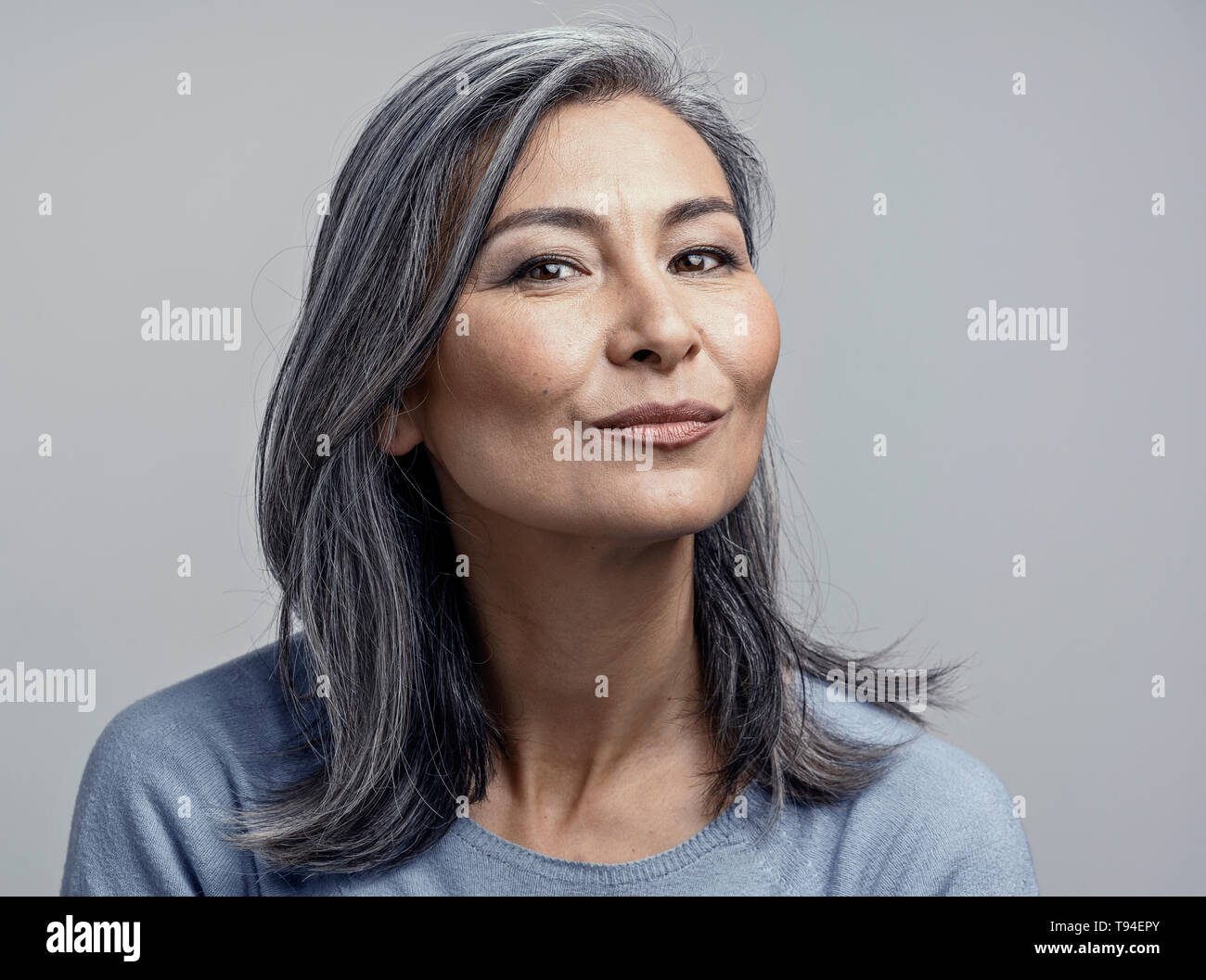 Charming Asian mature woman smiles at camera Stock Photo