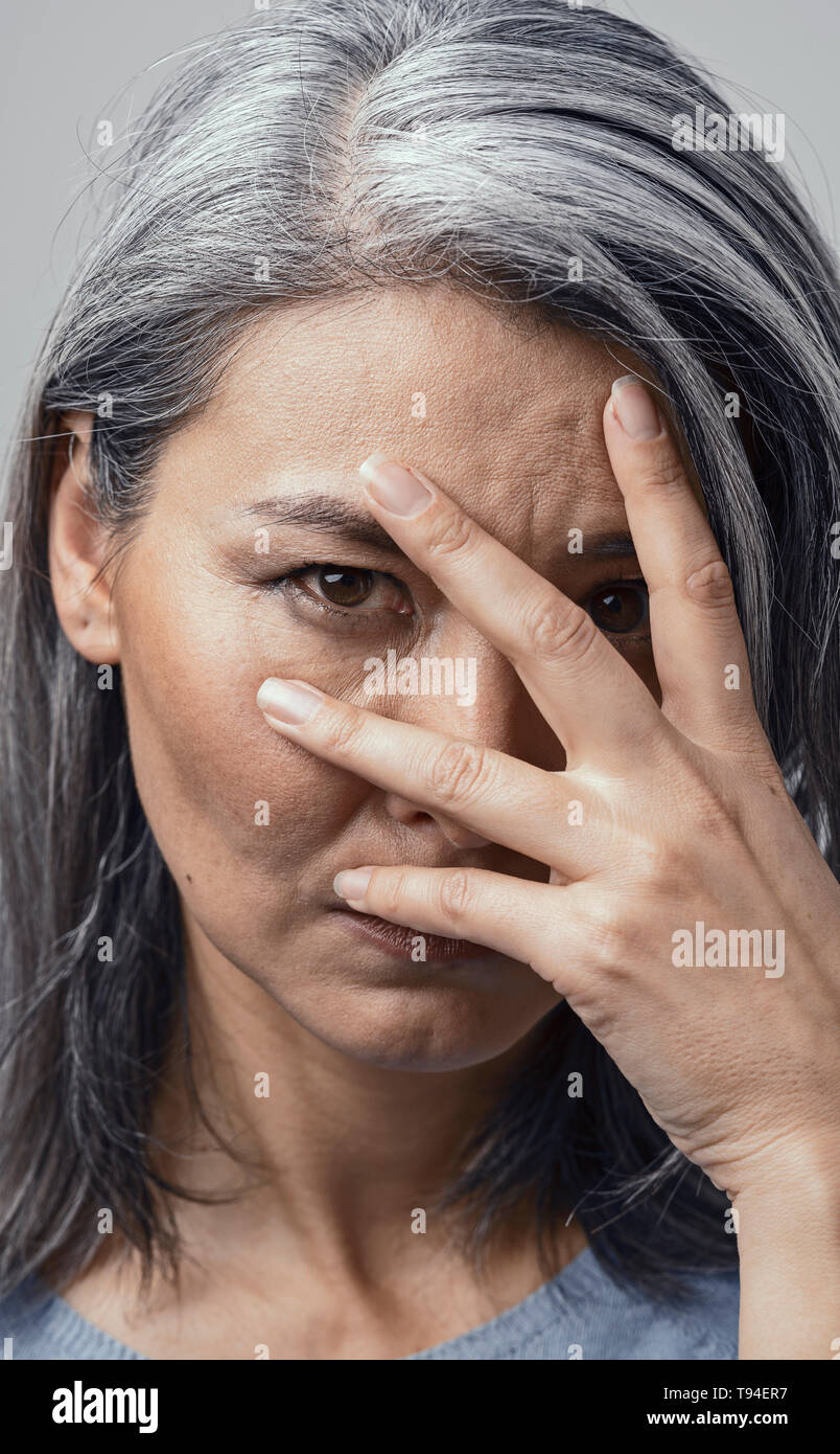 Beautiful woman is peeping through her fingers Stock Photo