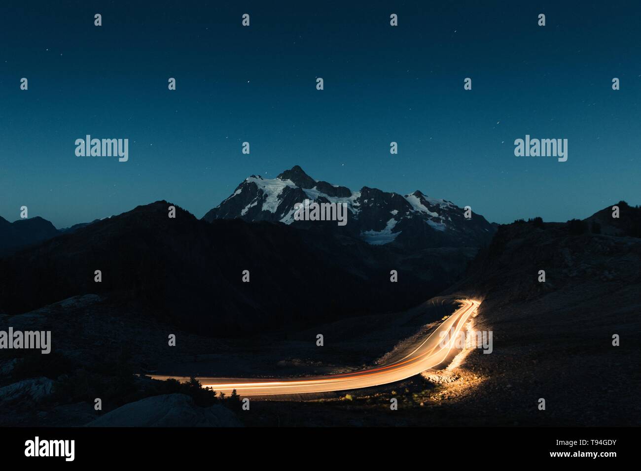 Amazing Night Sky With A Snowy Rocky Mountains In The Middle And A Dimly Lit Road Stock Photo Alamy Amazing Night Sky With A Snowy Rocky Mountains In The Middle And A Dimly Lit Road Stock Photo Alamy