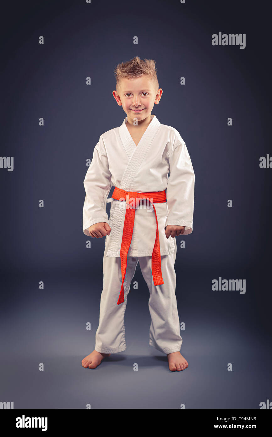portrait of a smiling child with kimono practicing martial arts, orange belt Stock Photo