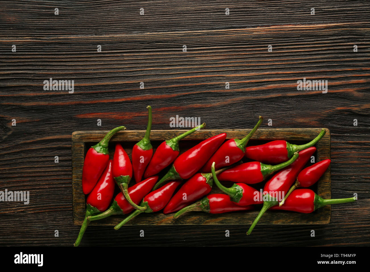 Plate with red hot chili peppers on wooden table Stock Photo - Alamy