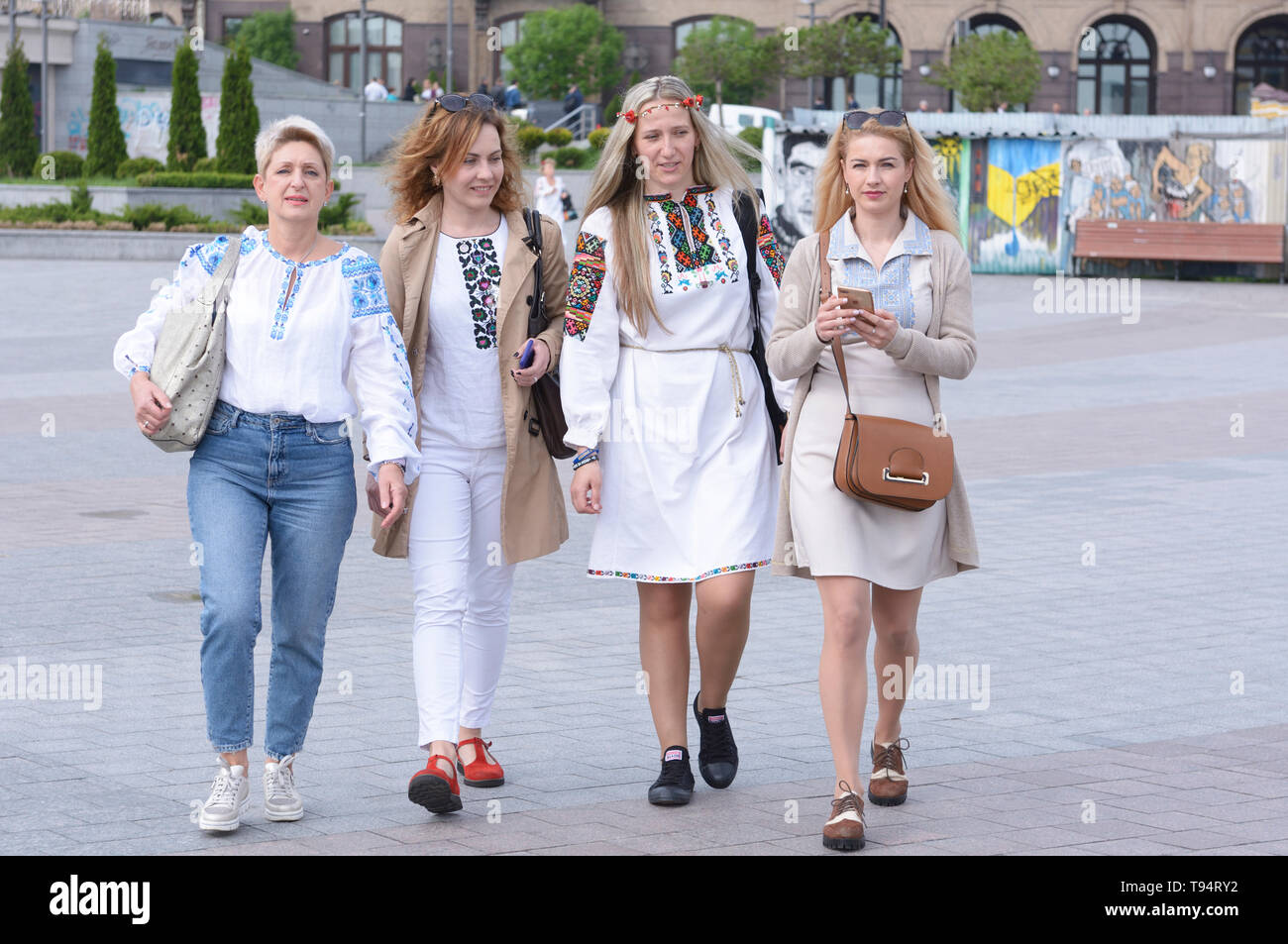 Women in Ukrainian embroidered shirts walking on the square