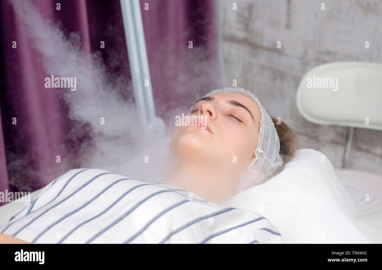 Beauty treatment of young female face, ozone facial steamer Stock Photo