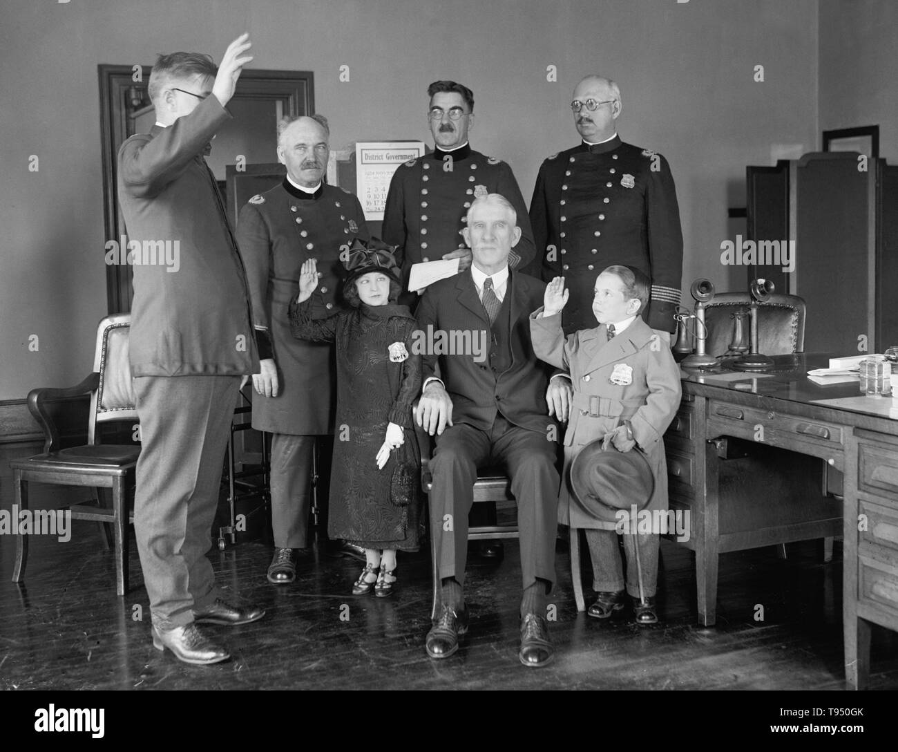 Entitled: 'Police Department swears in Singer midgets, Louis Vasshek & Dora Vieg.' Singer's Midgets were a popular vaudeville group in the first half of the 20th century. Leopold von Singer (May 3, 1877 - March 5, 1951) formed Singer's Midgets in 1912-13, and built the Liliputstadt, a 'midget city' at the 'Venice in Vienna' amusement park, where they performed. Stock Photo