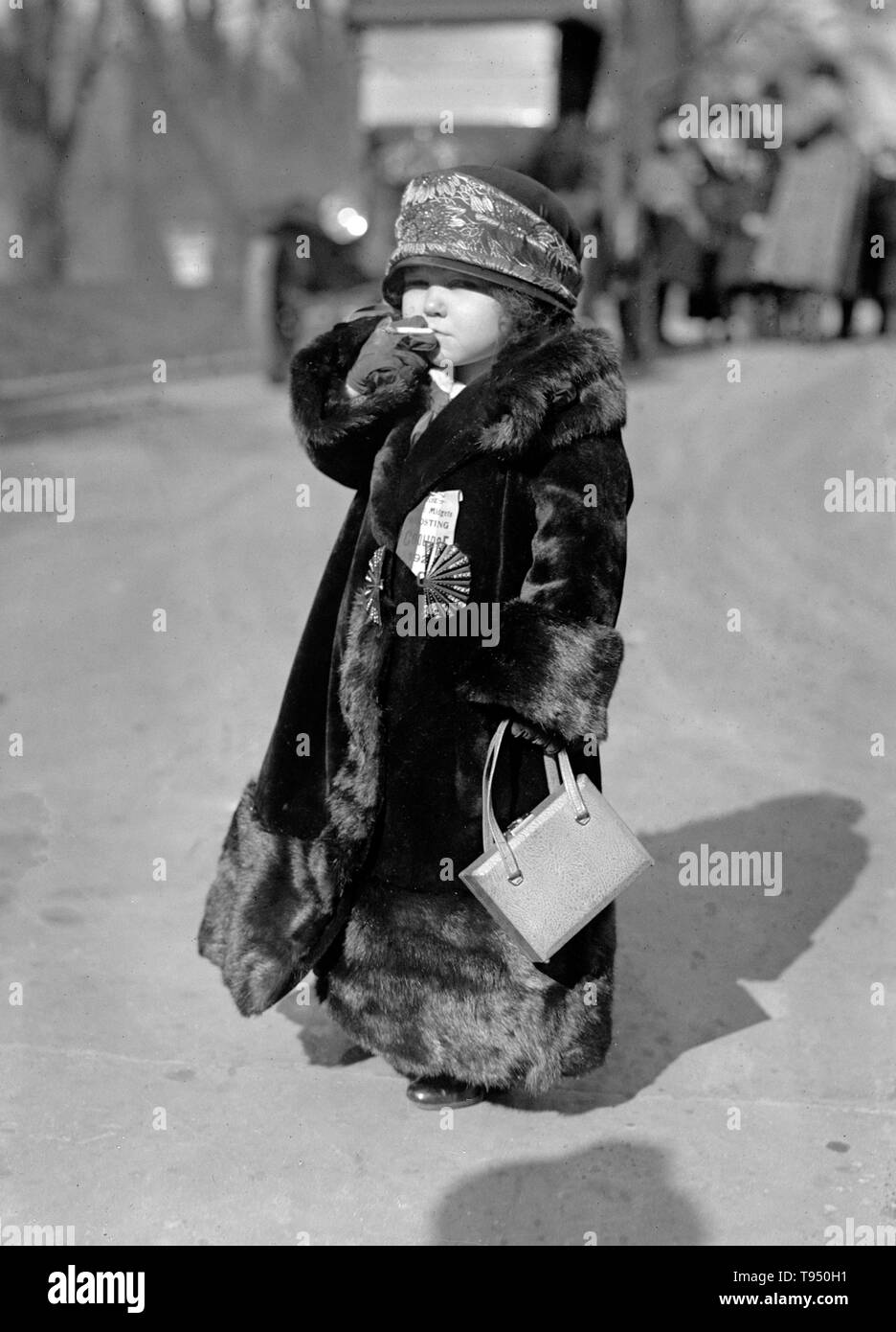 'The first organized touring Coolidge Marching Club to work for the nomination of the president comes to Washington Sunday morning. It is composed of 25 European midgets, headed by I.S. Rose, New Englander and impresario. The midgets wear buttons and ribbons on which is inscribed Coolidge 1925.' Midget is a term for a person of unusually short stature that is considered by some to be pejorative. Stock Photo