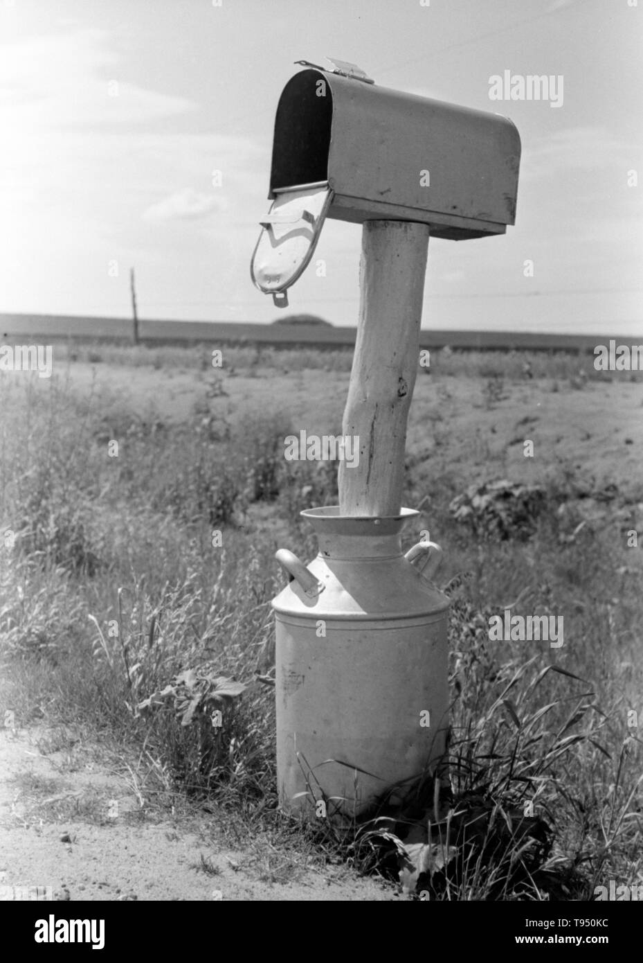 Entitled: 'Mail box set up in milk can near Hydro, Oklahoma.' Before the introduction of rural free delivery (RFD) by the Post Office in 1896, many rural residents had no access to the mail unless they collected it at a post office located many miles from their homes or hired a private express company to deliver it. For this reason, mailboxes did not become popular in rural America until curbside RFD mail delivery by the Post Office was an established service. Stock Photo