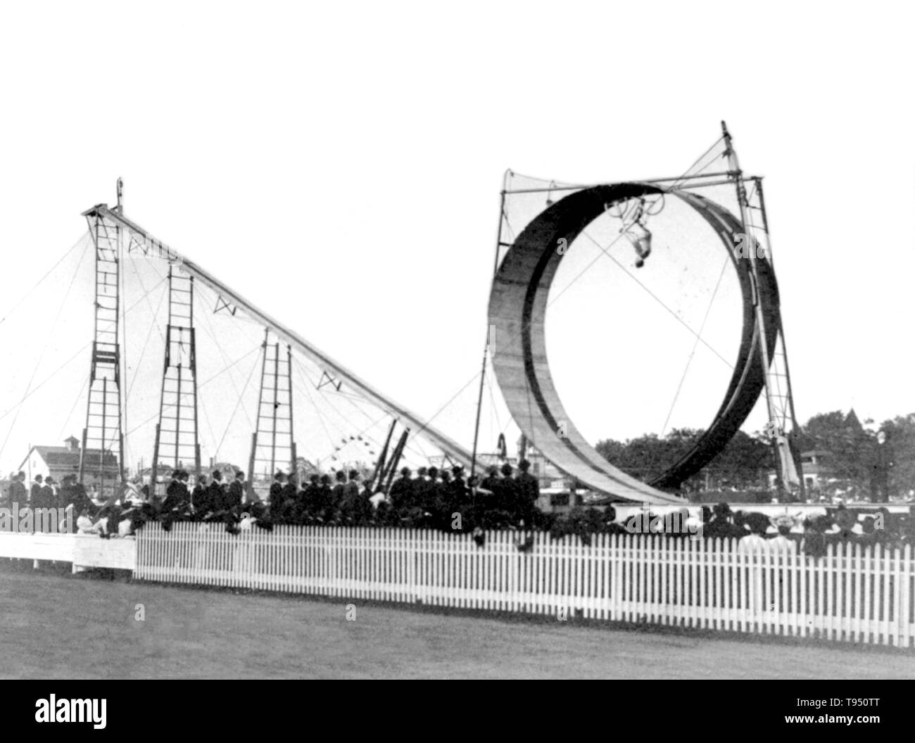 Entitled: 'Diavolo performing his bicycle daredevil act before a large audience.' Conn Baker (January 31, 1871 - October 8, 1944) was an American daredevil and artist. He took up bicycle racing as a teenager in the 1880s. He soon held several world records for speed and endurance. Baker was the first person to perfect a 'loop-the-loop' using a safety bicycle. He joined the Forepaugh and Sells Circus in 1901, performing under the stage name of J.C. Stock Photo