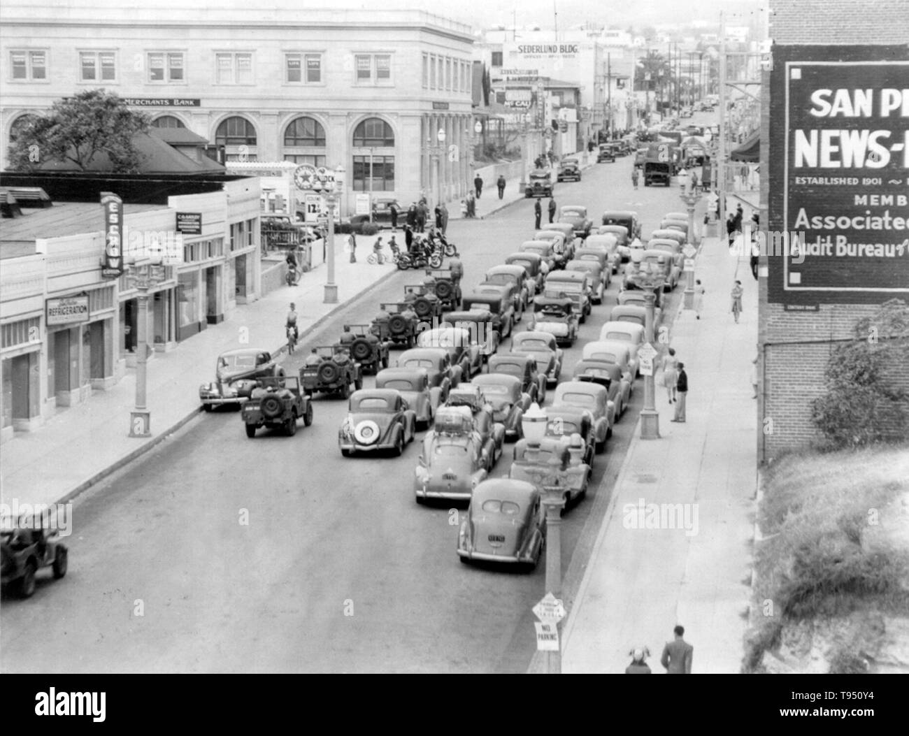 Entitled: 'Caravan of cars, with many military escort vehicles, W. 7th St. & S. Pacific Avenue.' The internment of Japanese-Americans during WWII was the forced relocation and incarceration in camps of 110,000-120,000 people of Japanese ancestry (62% of the internees were US citizens) ordered by President Roosevelt shortly after Japan's attack on Pearl Harbor. Japanese-Americans were incarcerated based on local population concentrations and regional politics. Stock Photo