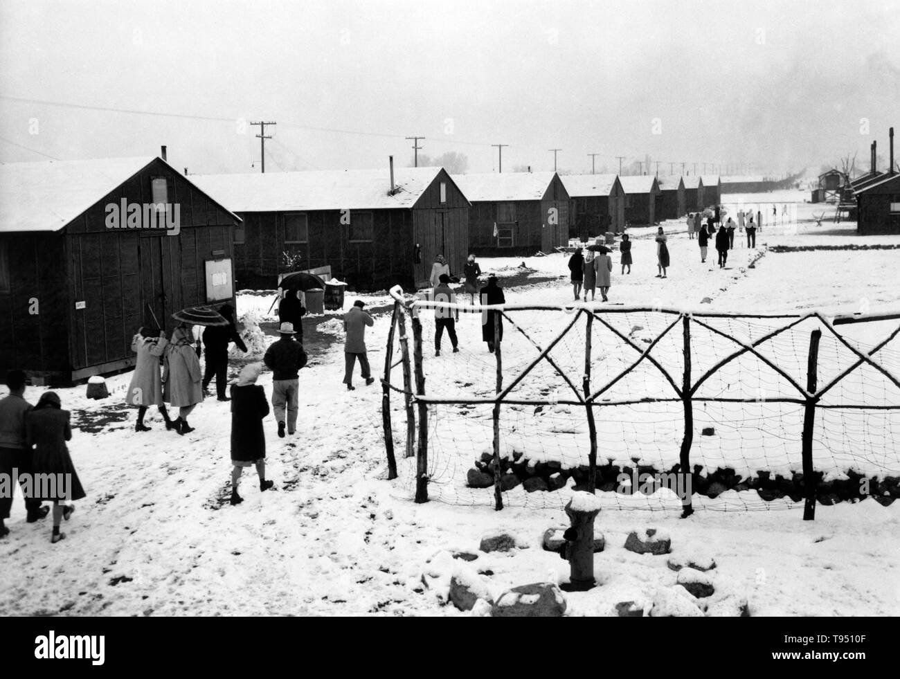 Entitled: 'People leaving Buddhist church, winter, Manzanar Relocation Center, California.' The internment of Japanese-Americans during WWII was the forced relocation and incarceration in camps of 110,000-120,000 people of Japanese ancestry (62% of the internees were US citizens) ordered by President Roosevelt shortly after Japan's attack on Pearl Harbor. Japanese-Americans were incarcerated based on local population concentrations and regional politics. Stock Photo