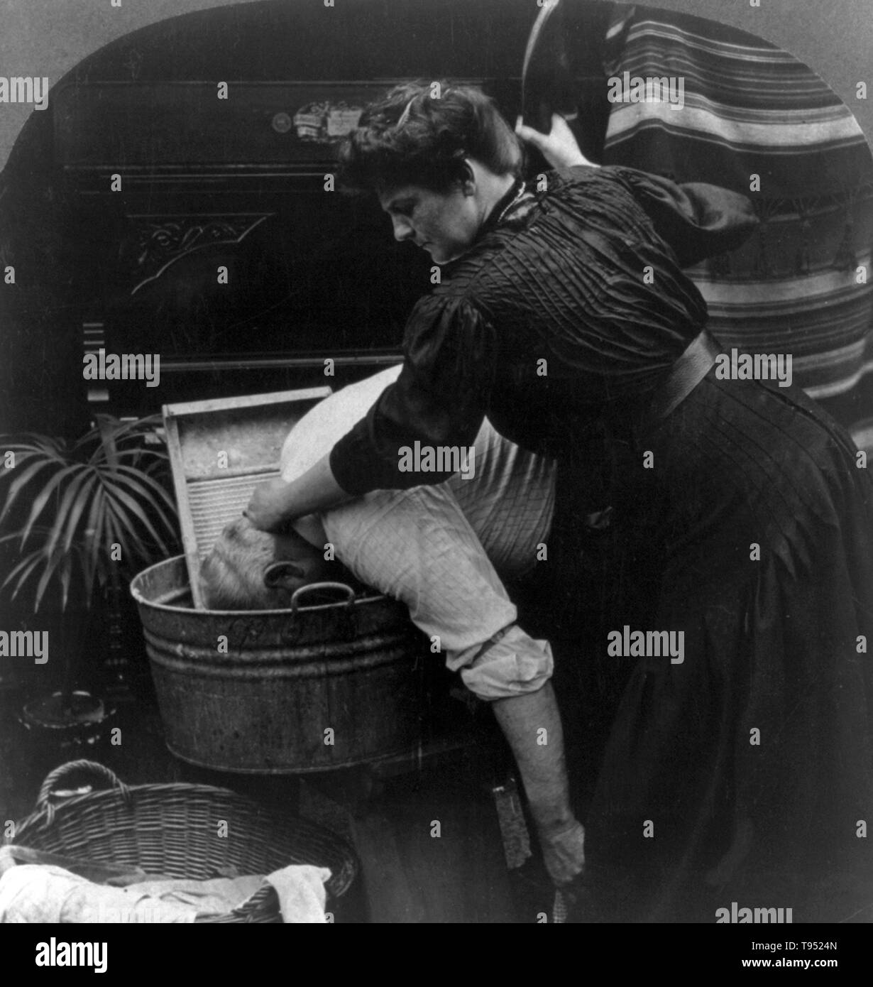 Entitled: 'O'Brien's Monday' shows a woman forcing man to wash clothes. Cropped stereograph photographed by E.W. Kelley, 1906. Stock Photo