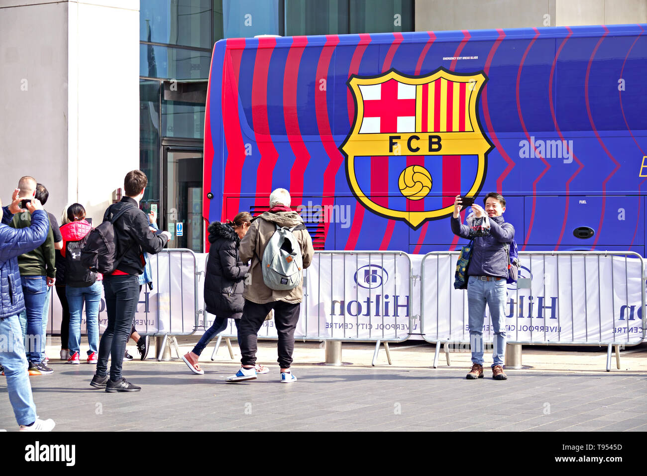 People pose for photographs in front of the FC Barcelona team coach in front of the Hilton Hotel Liverpool UK Stock Photo