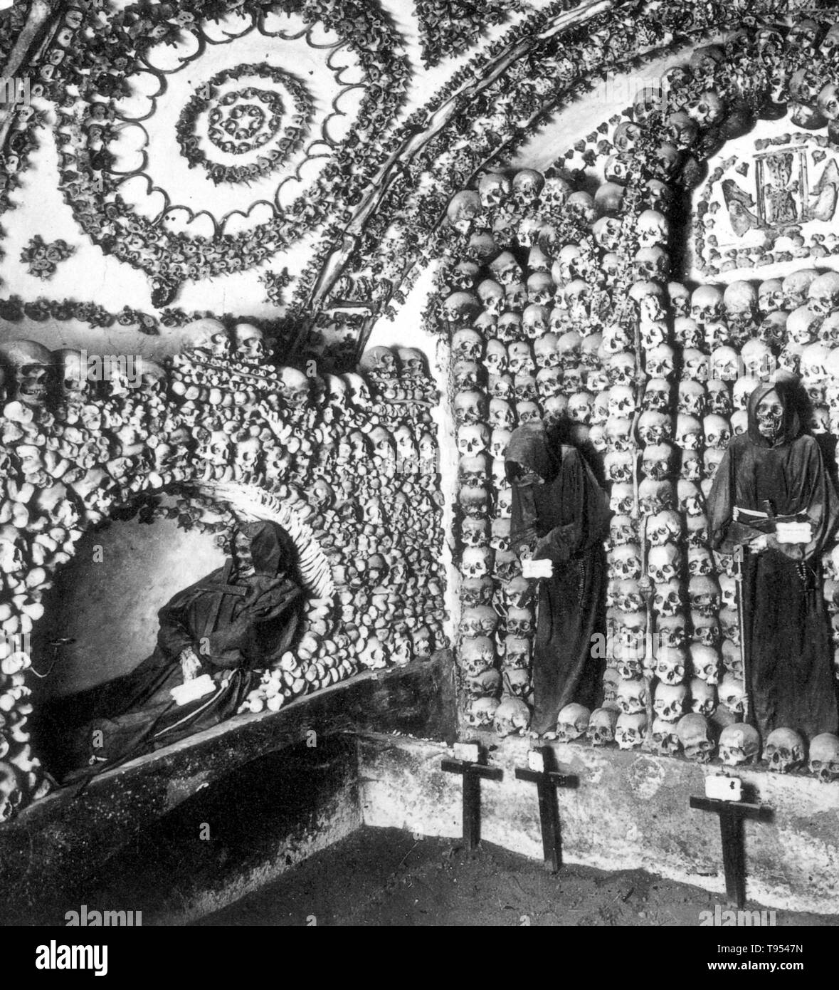 The Capuchin Crypt is a small space comprising several tiny chapels located beneath the church of Santa Maria della Concezione dei Cappuccini on the Via Veneto near Piazza Barberini in Rome, Italy. It contains the skeletal remains of 3,700 bodies believed to be Capuchin friars buried by their order. The Catholic order insists that the display is not meant to be macabre, but a silent reminder of the swift passage of life on Earth and our own mortality. Stock Photo