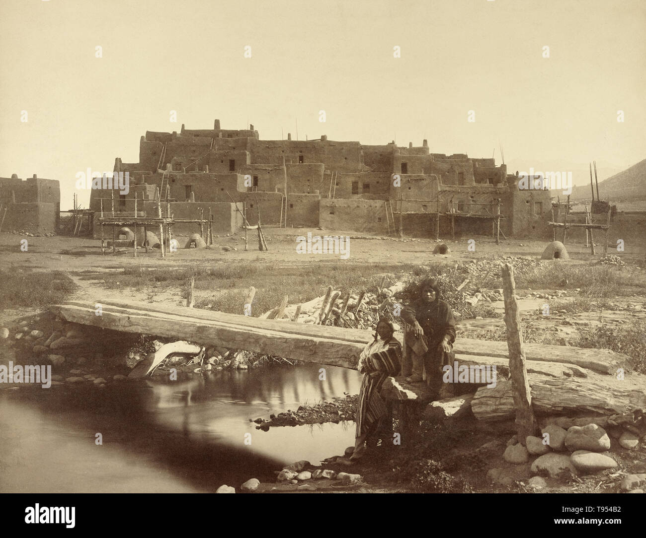 Pueblo de Taos, Northern New Mexico, Denver and Rio Grande Railway. William Henry Jackson (American, 1843 - 1942); 1880; Albumen silver print. Taos Pueblo (or Pueblo de Taos) is an ancient pueblo belonging to a Tiwa-speaking Native American tribe of Puebloan people. It lies about 1 mile north of the modern city of Taos, New Mexico, USA. The pueblos are considered to be one of the oldest continuously inhabited communities in the United States. This has been designated a UNESCO World Heritage Site. Stock Photo