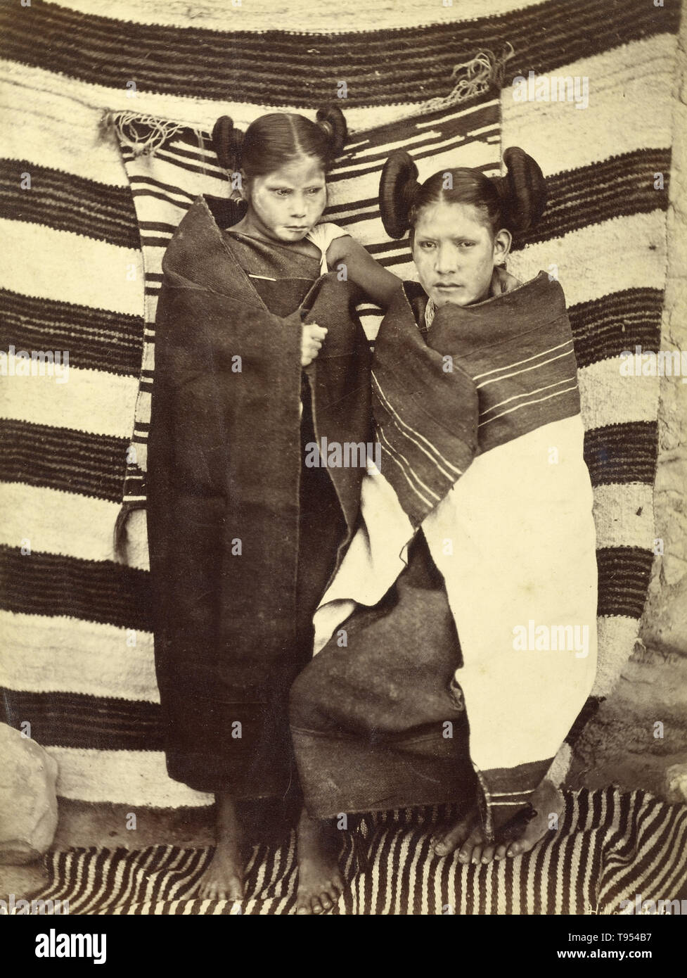 Hopi girls in traditional dress, taken by John K. Hillers (American, 1843 - 1925) in 1879. Albumen silver print. The Hopi are a Native American tribe, who primarily live on the Hopi Reservation in northeastern Arizona. According to the 2010 census, there were 19,327 Hopi in the United States. Stock Photo