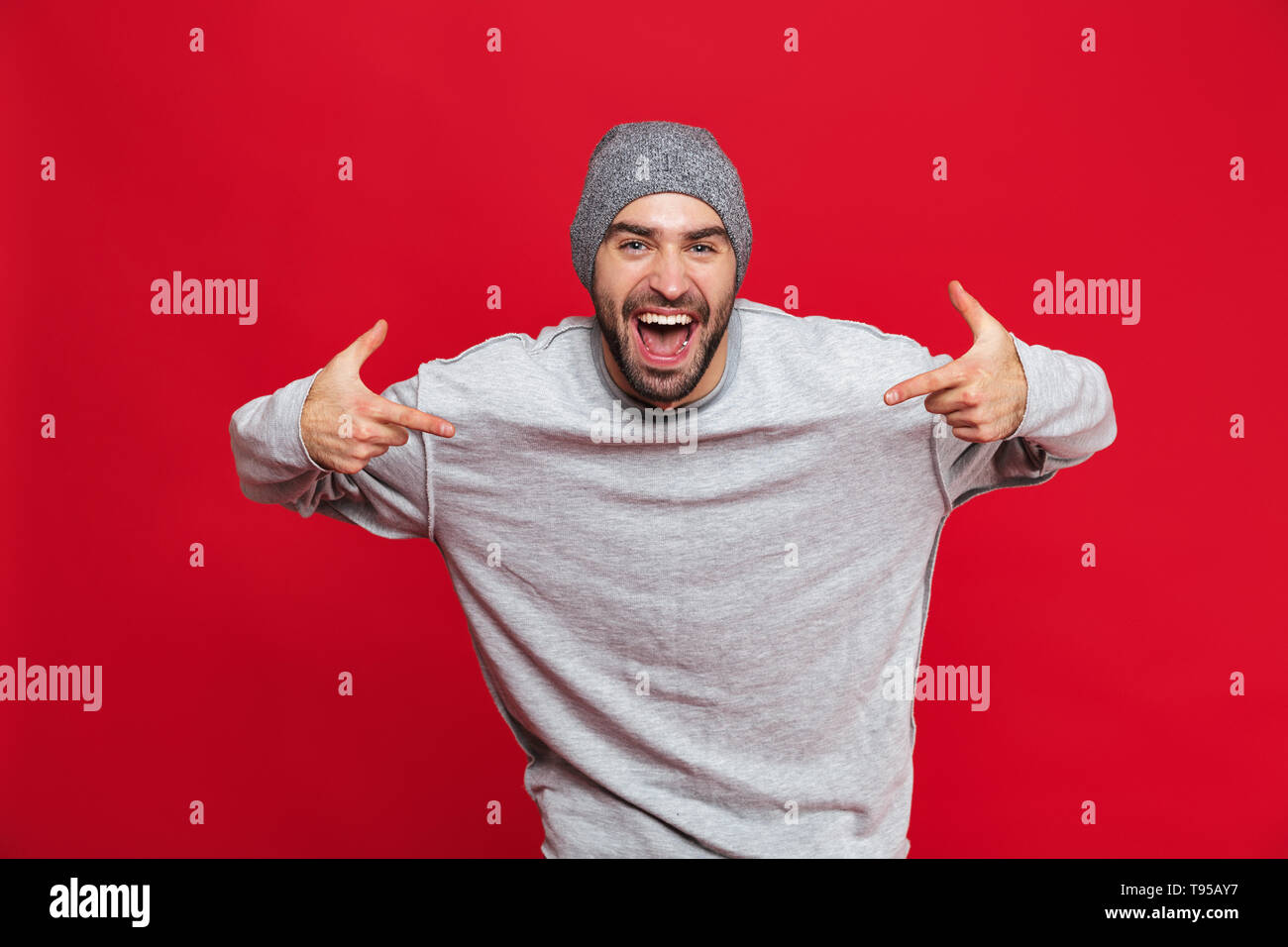 Image of ecstatic man 30s having stubble laughing and pointing fingers ...
