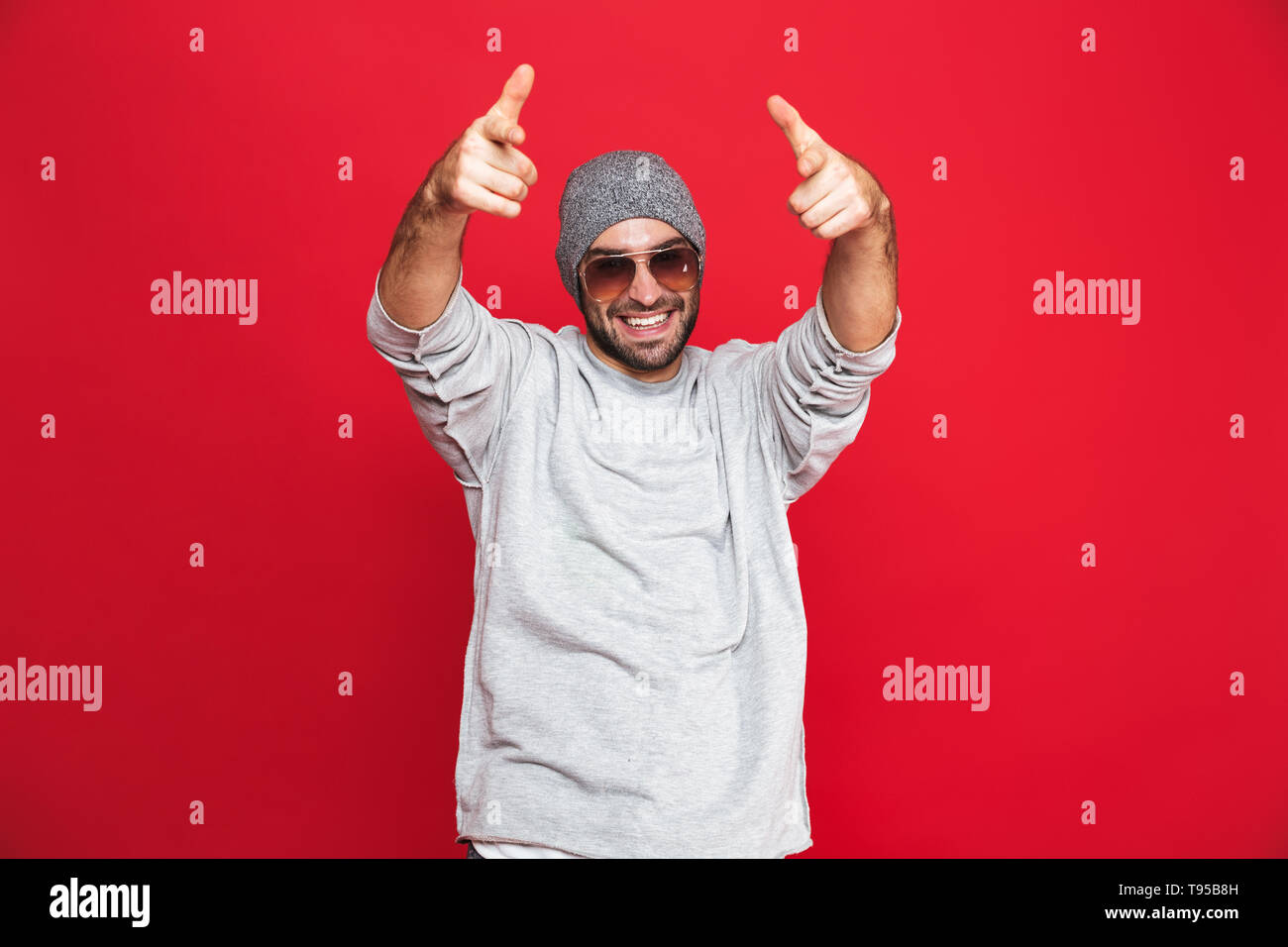 Image of european man 30s in sunglasses laughing and pointing fingers ...