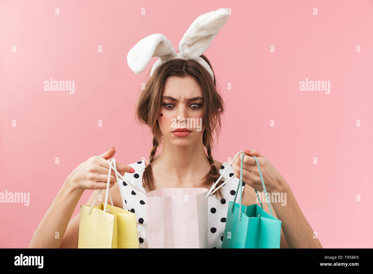 Portrait of a pretty lovely girl wearing bunny ears standing isolated ...