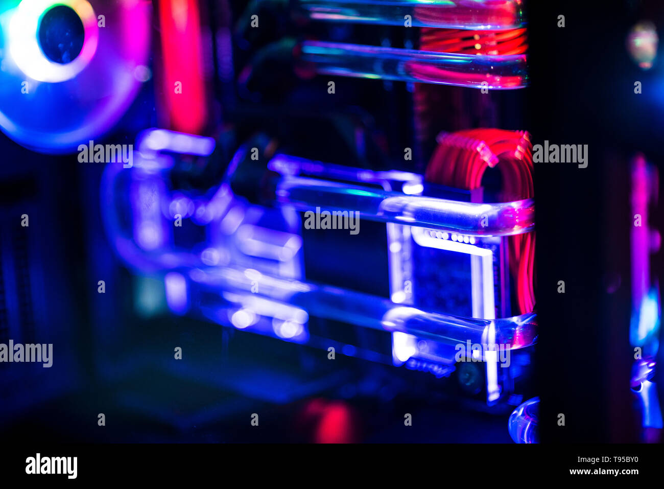 Inside a high performance computer. Computer circuit board and CPU cooling fans illuminated by internal LEDs inside a server class computer. Stock Photo