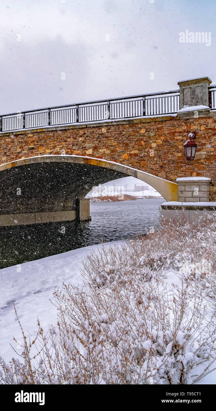 Vertical Oquirrh Lake with view of snowy trail and bridge Stock Photo