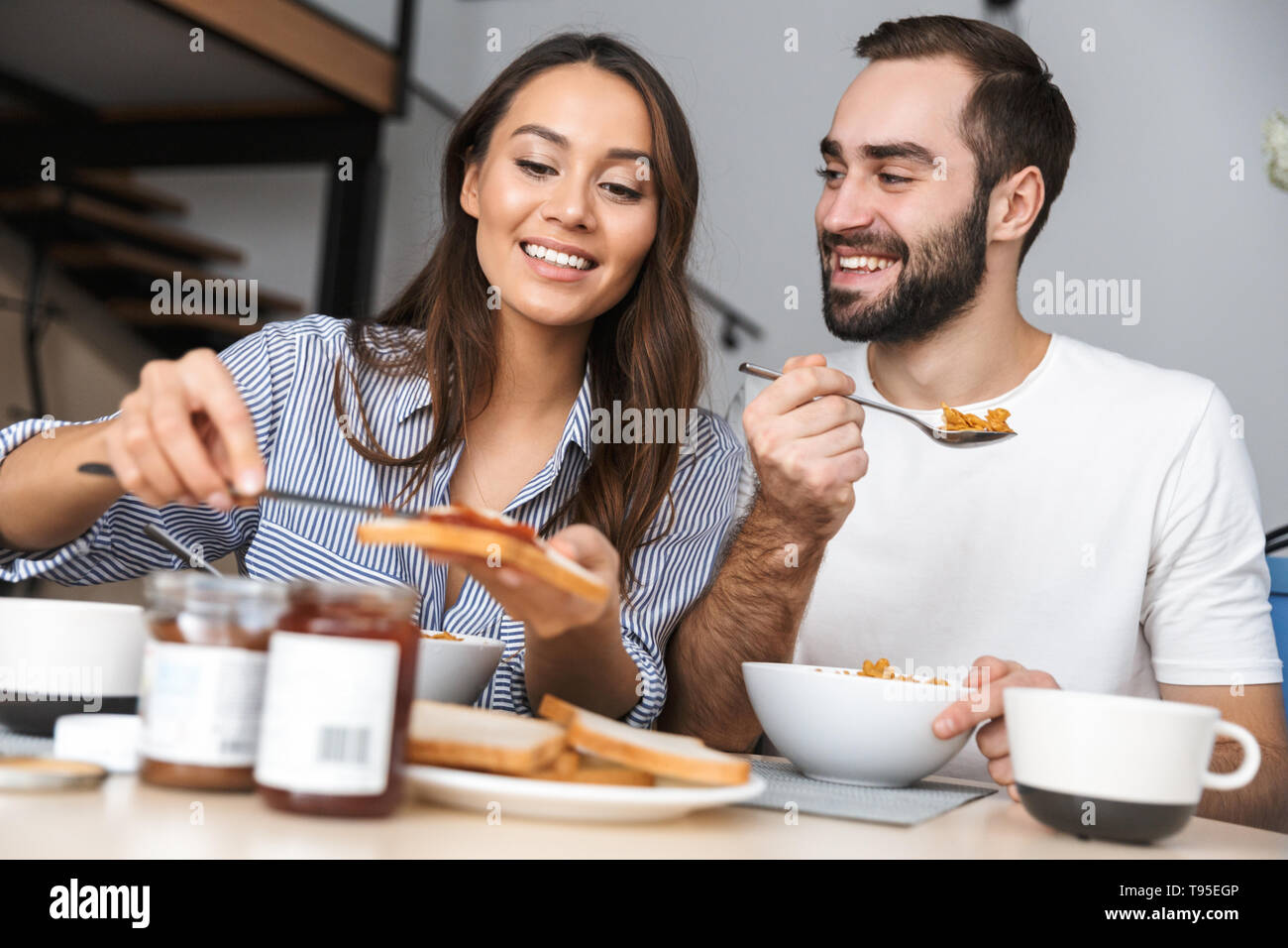 Happy multiethnic couple having breakfast at the kitchen Stock Photo