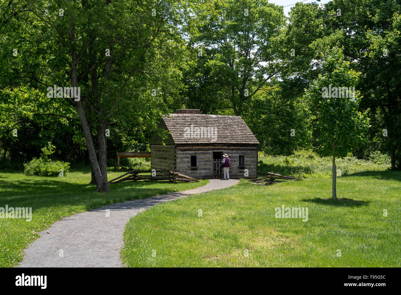 Chantilly, Virginia, USA -- May 16, 2019. A woman tourist examines a replication of slaves' quarters at the Sully Plantation in Chantilly, Virginia, U Stock Photo